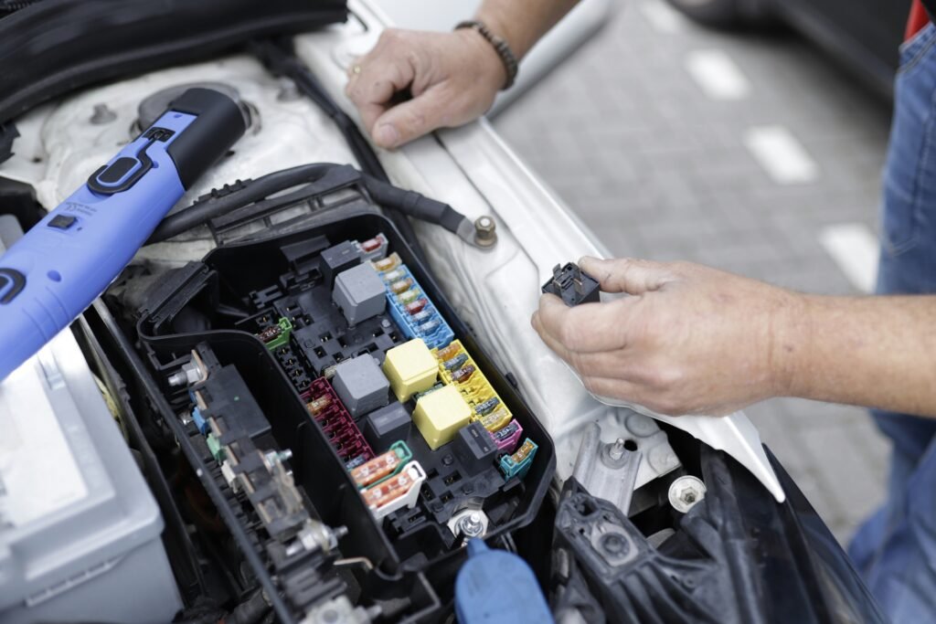 Close-up of Testing Car Battery with Multimeter showing voltage reading on car battery terminals